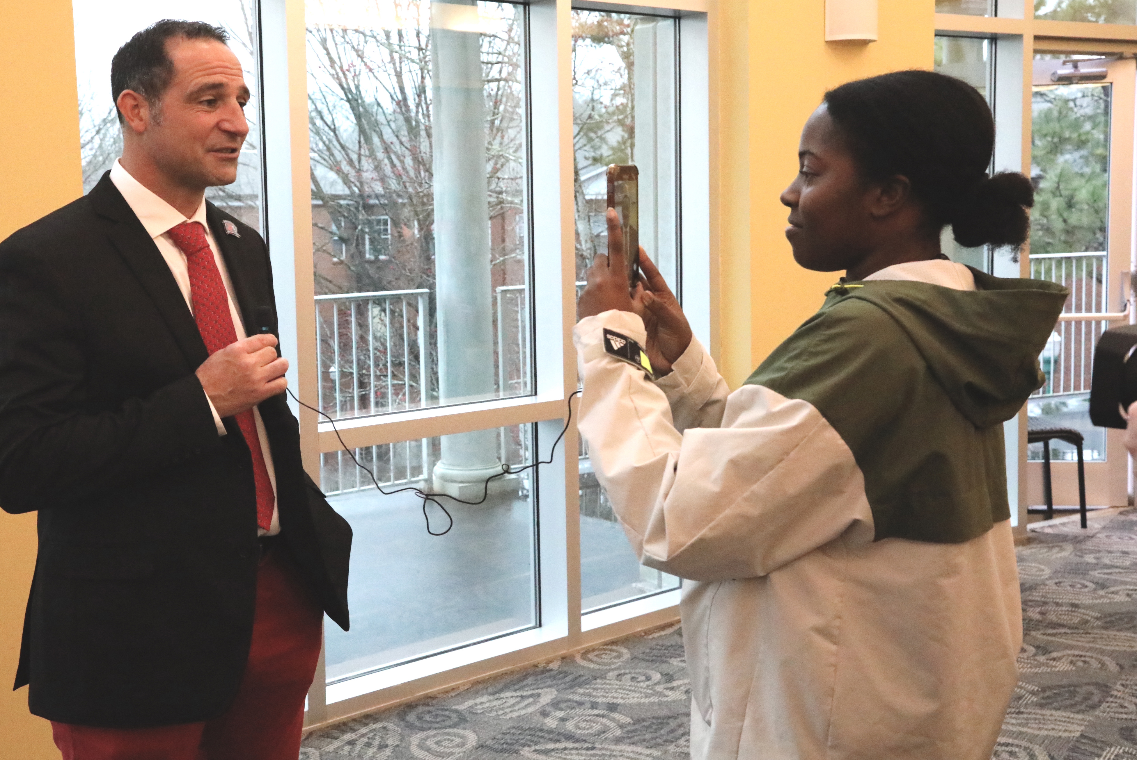 Student talks with new football coach